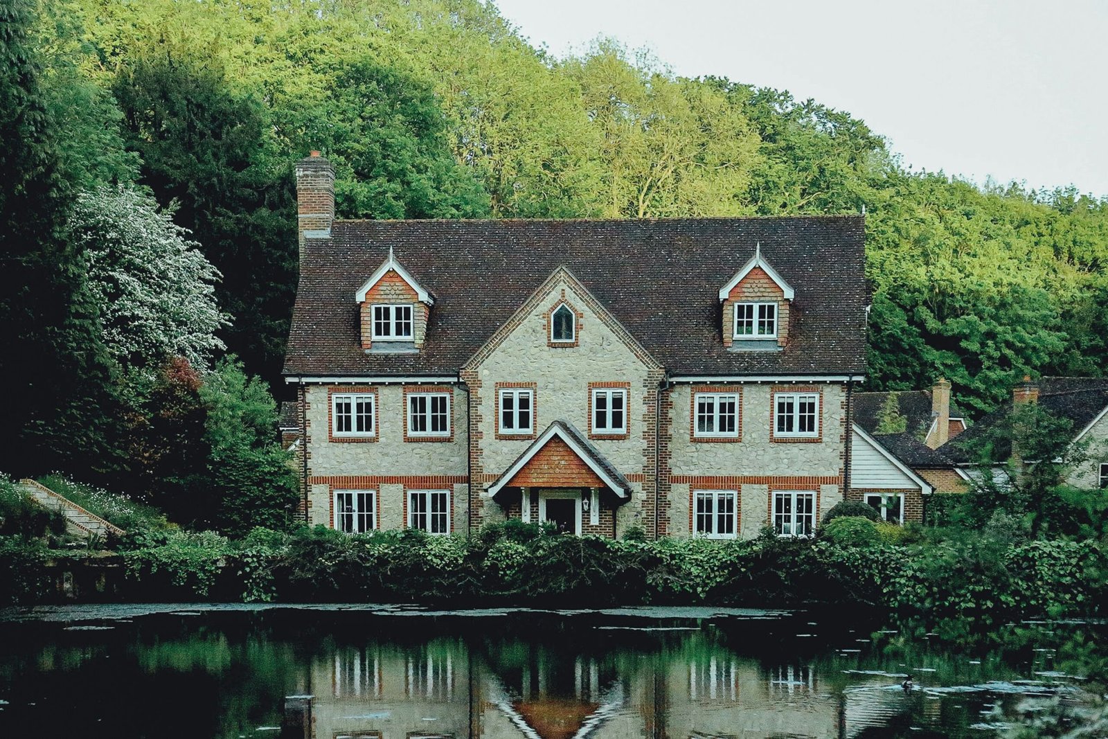 concrete house near a body of water and forest